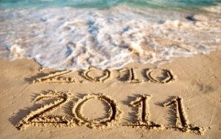 2010 and 2011 Is Written In The Sand. 2010 Is being Washed Away By A Wave