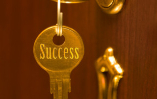 Door With Keyhole. Two Keys on a Keyring, one is inside the lock the other is hanging with the text "Success" on it. A Conept.