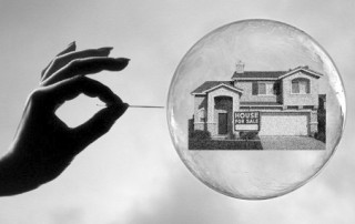 Hand With Needle Popping A Bubble With A House In It. Represents The Housing Bubble