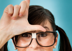 Woman With Pig Tails And "Nerd" glasses With Her Hand On Her Forehead Making An L