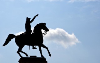 Cowboy statue silhouette with blue sky and cloud background