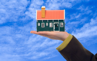 Hand holding house with bluesky background