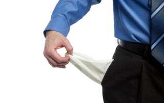 Man In Business Ware Pulling out His Pockets To Symbolize Being Broke