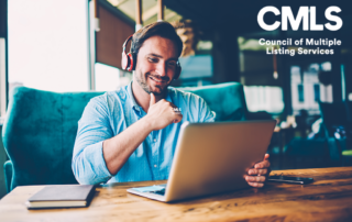 Positive handsome businessman in modern headphones watching funny webinar about productive work strategy on modern digital computer connected to 4G internet sitting in stylish cafeteria