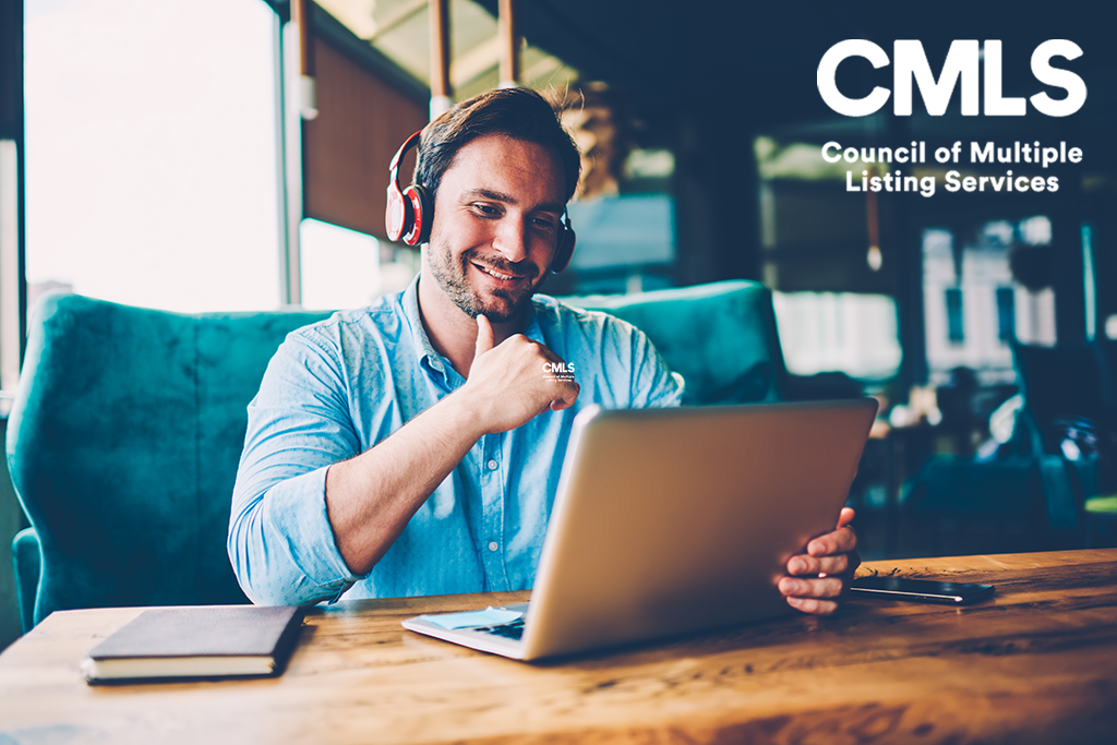 Positive handsome businessman in modern headphones watching funny webinar about productive work strategy on modern digital computer connected to 4G internet sitting in stylish cafeteria