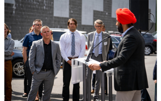 Webmasters Speaker- man in orange turban presenting at an outdoor gathering