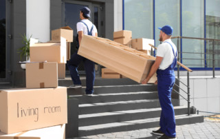 Male movers carrying shelving unit into new house