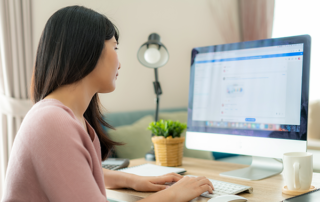 Woman sitting at desk looking at computer