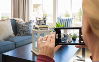 Woman taking photo of interior or home with cell phone