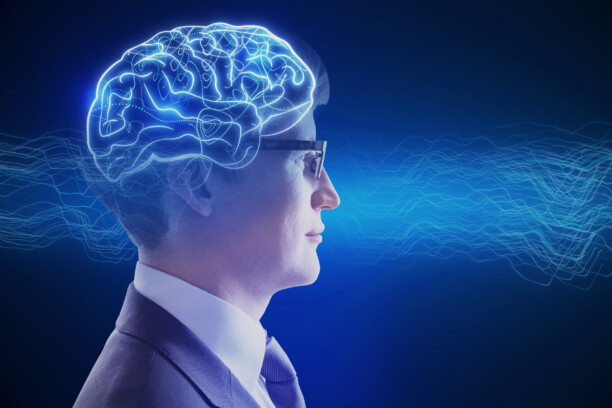 Side portrait of attractive young businessman with creative digital brain hologram on blue background. Hi-tech innovation and AI concept